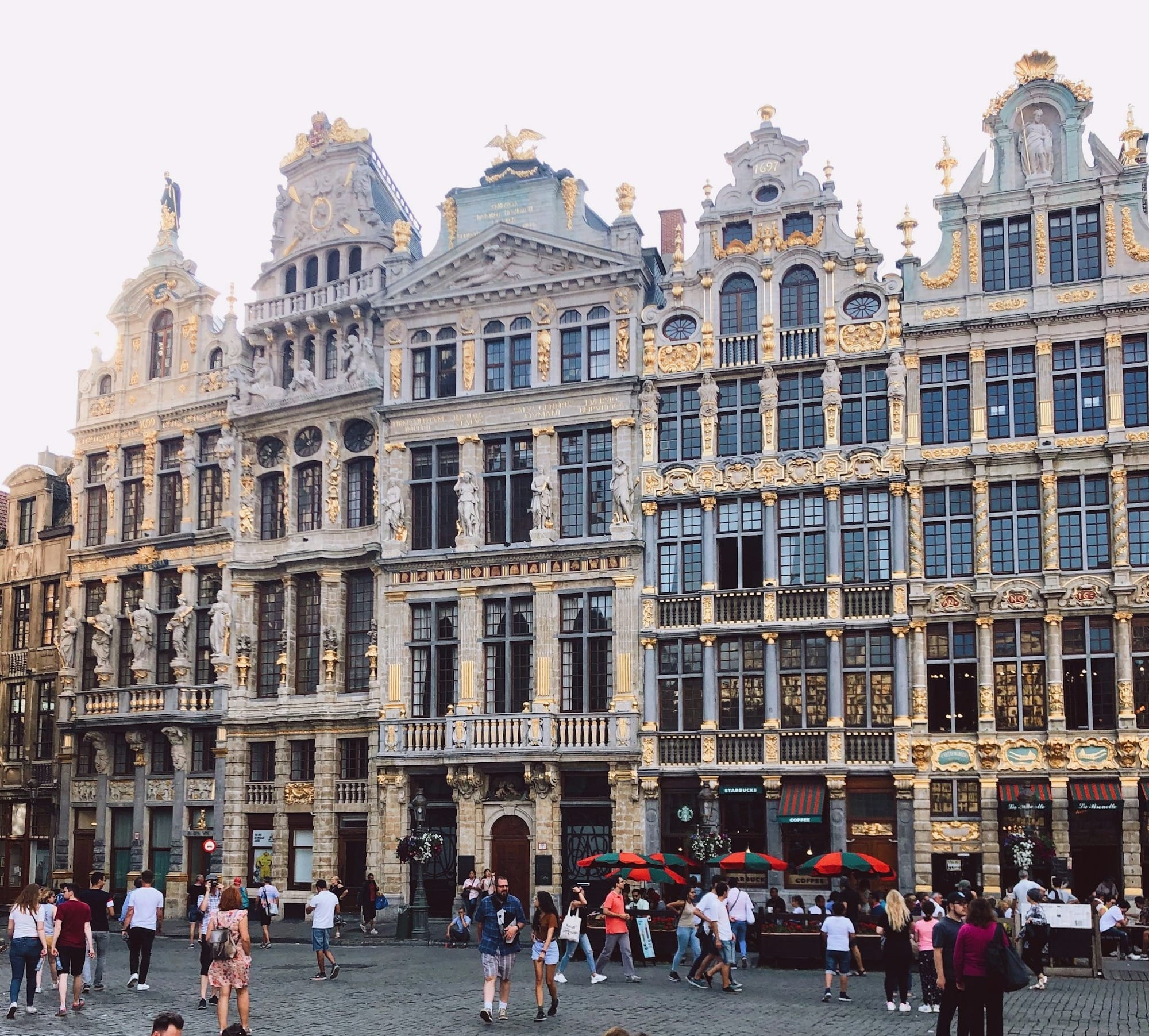 people sitting and standing beside high buildings during daytime