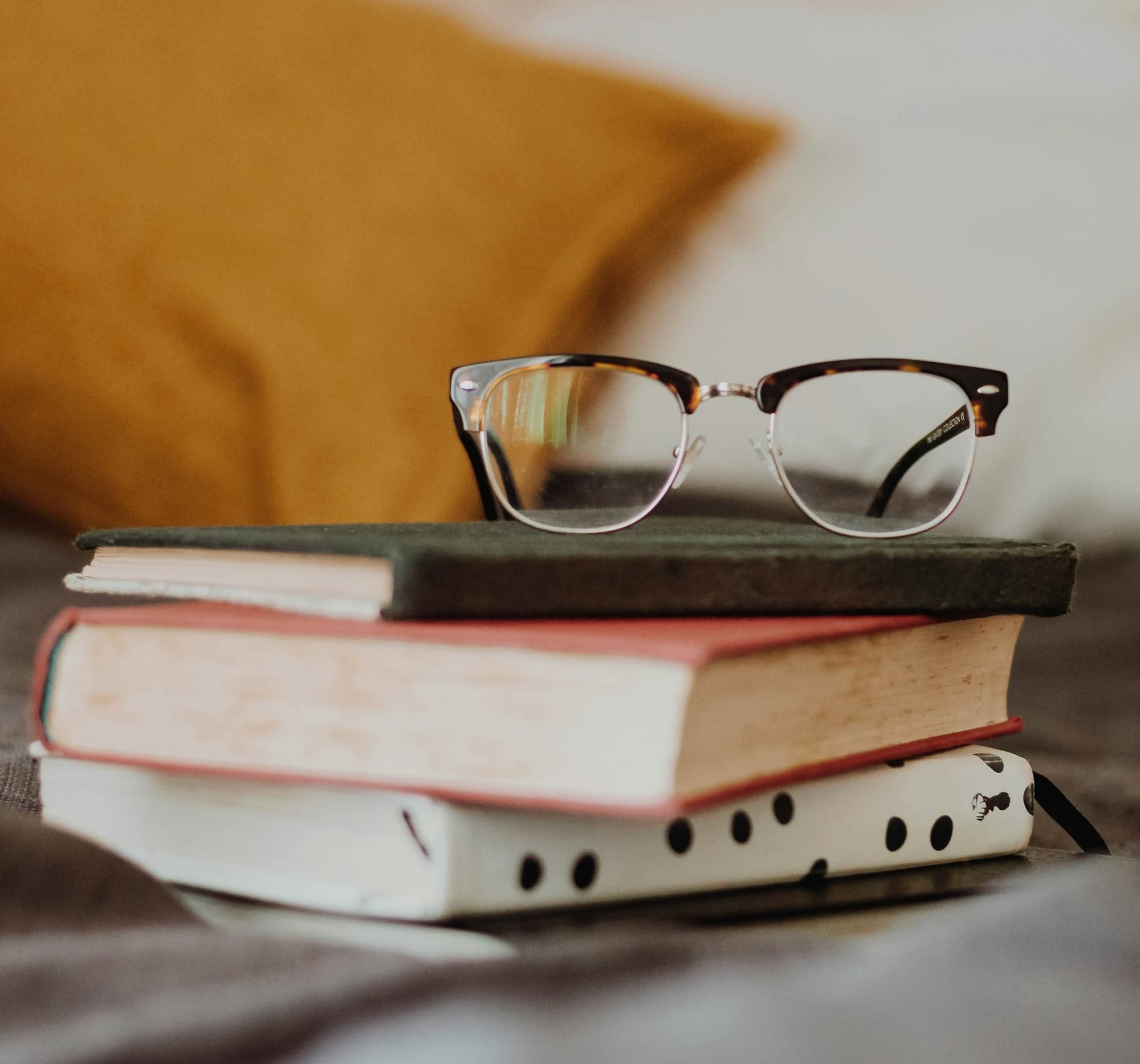 club master eyeglasses on pile of three books